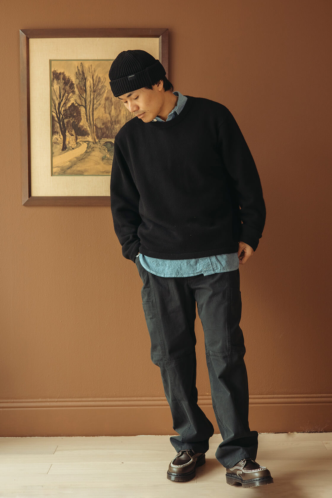 Taiga Takahashi Lot. 303 Coverall Jacket in Mix Brown, Hender Scheme Leather Nest Bag in Natural, FrizmWORKS OG Oversized Stripe Shirt in Blue, Auralee Light Wool Max Gabardine Shorts in Dark Brown, and Visvim Landers Boots-Folk in Black.