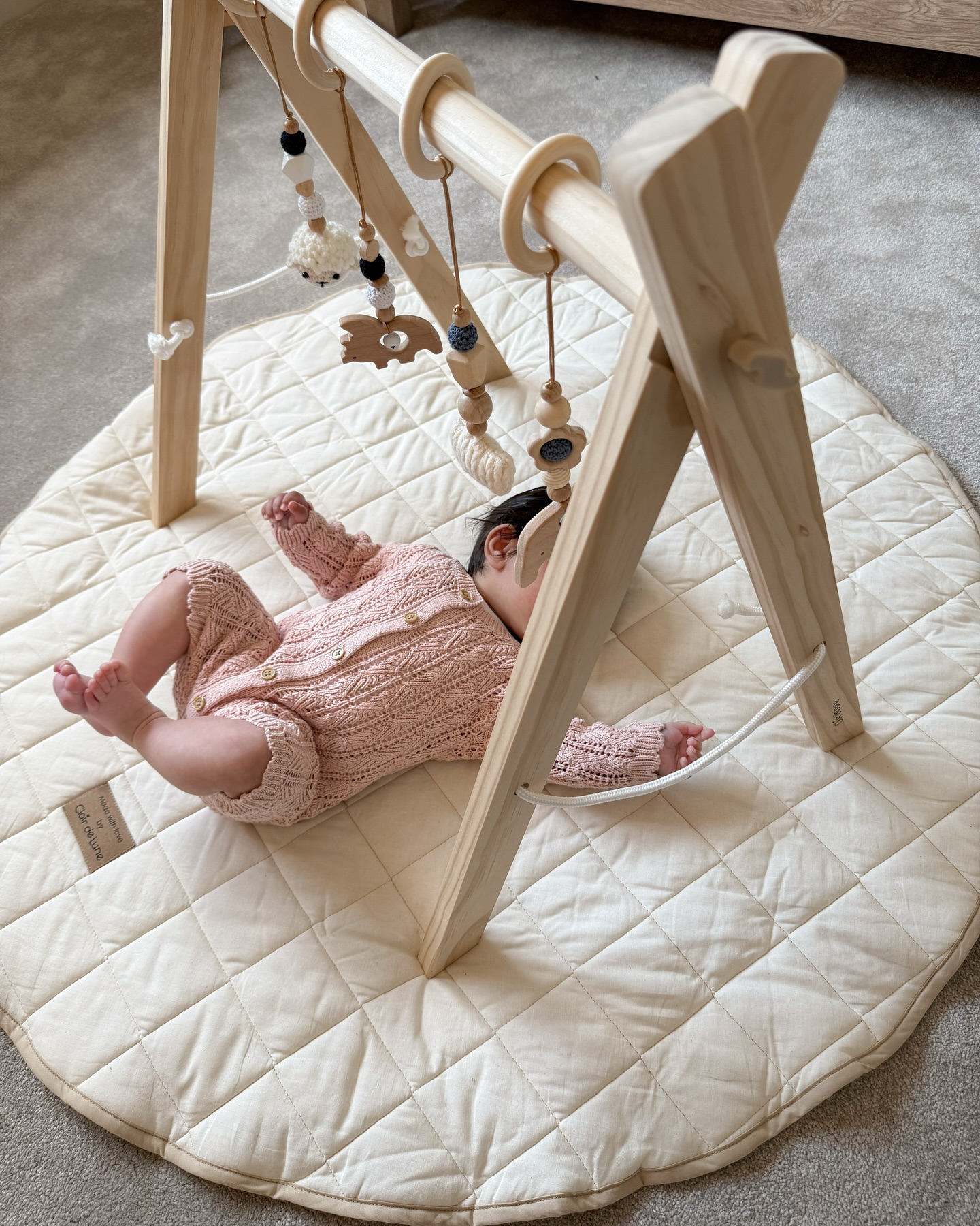 Baby Lying on the Organic Play Mat & Playing with toys on the Wooden Play Gym Set | Baby Play Mats & Gyms | Baby Tummy Time Toys - Clair de Lune UK