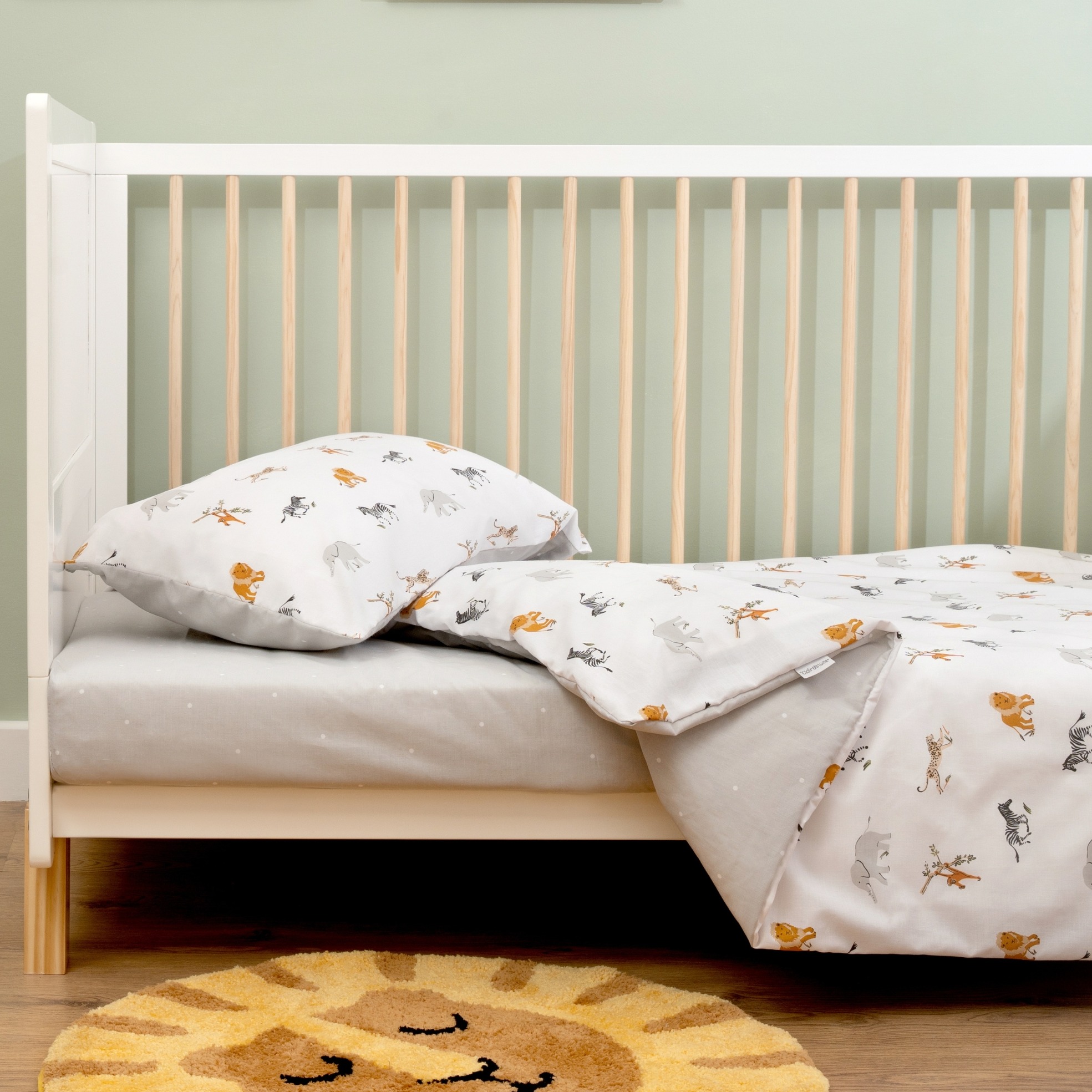 The lifestyle setting of the Reversible Jungle Dream Cot Bed Duvet Cover and Pillowcase Set | Bedding - Clair de Lune UK