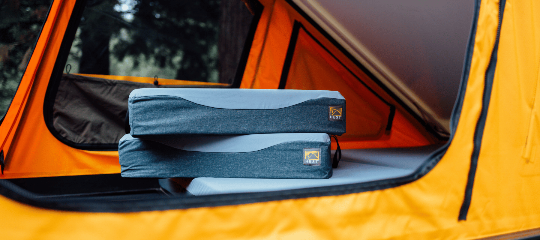 HEST Foamy rolled up next to soft shell rooftop tent for easy storage and setup