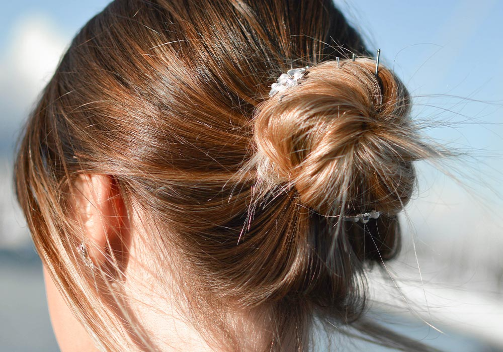 Glänzende hellbraune Haare in einem lockeren Dutt.