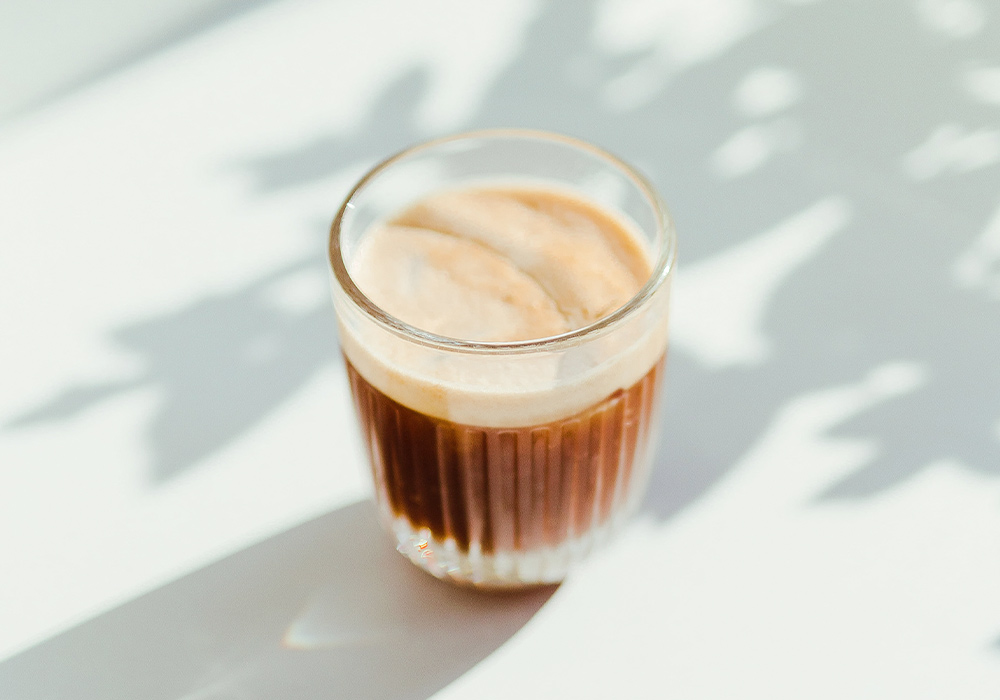 Kaffee mit Milchschaum in einem Glas.