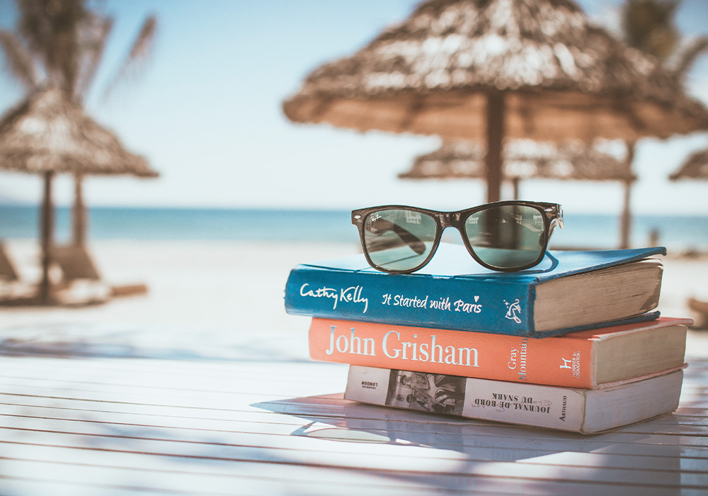 3 Bücher liegen auf einem Tisch am Strand