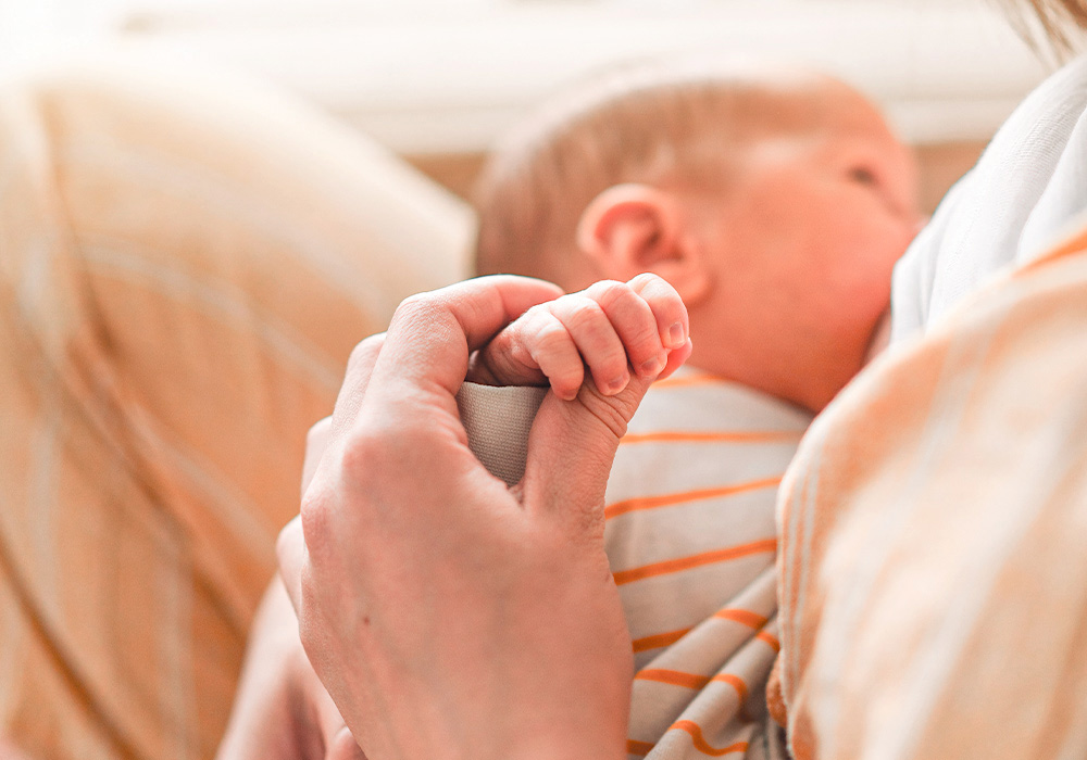 Eine Frau hält ein Baby in den Armen und stillt es.