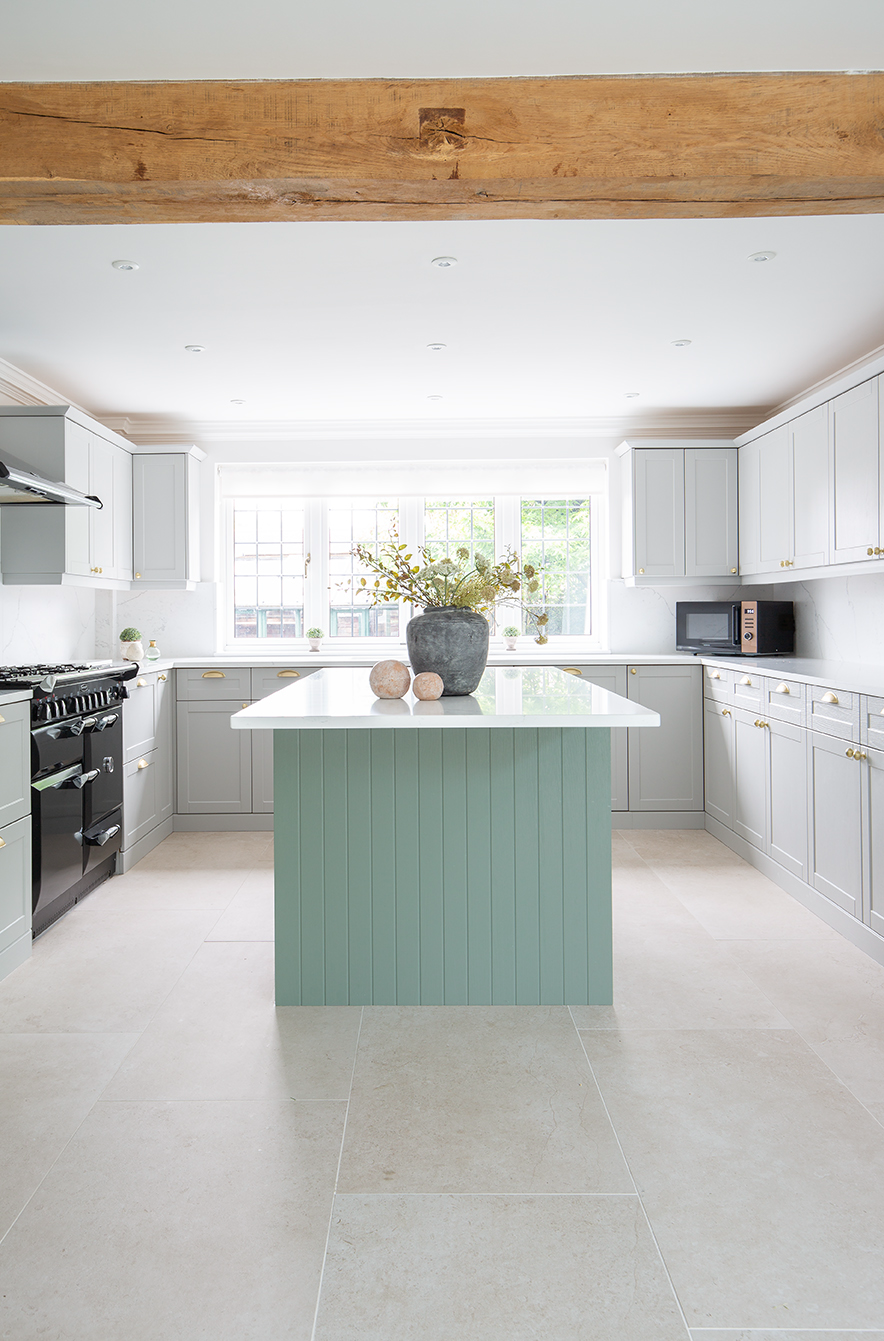 orwell Natural tiles with a kitchen island with cabinets and a wooden beam