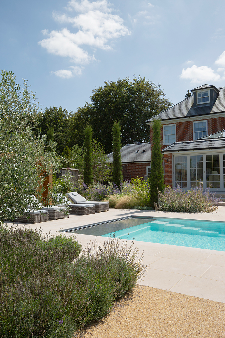 Garden Patio with Dijon Tumbled paving with pool and brick house