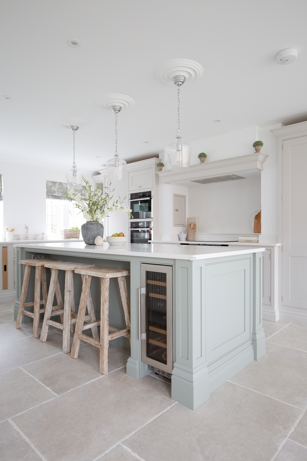 ivory stone effect porcelain flooring with rustic oak kitchen stools and pale blue kitchen island