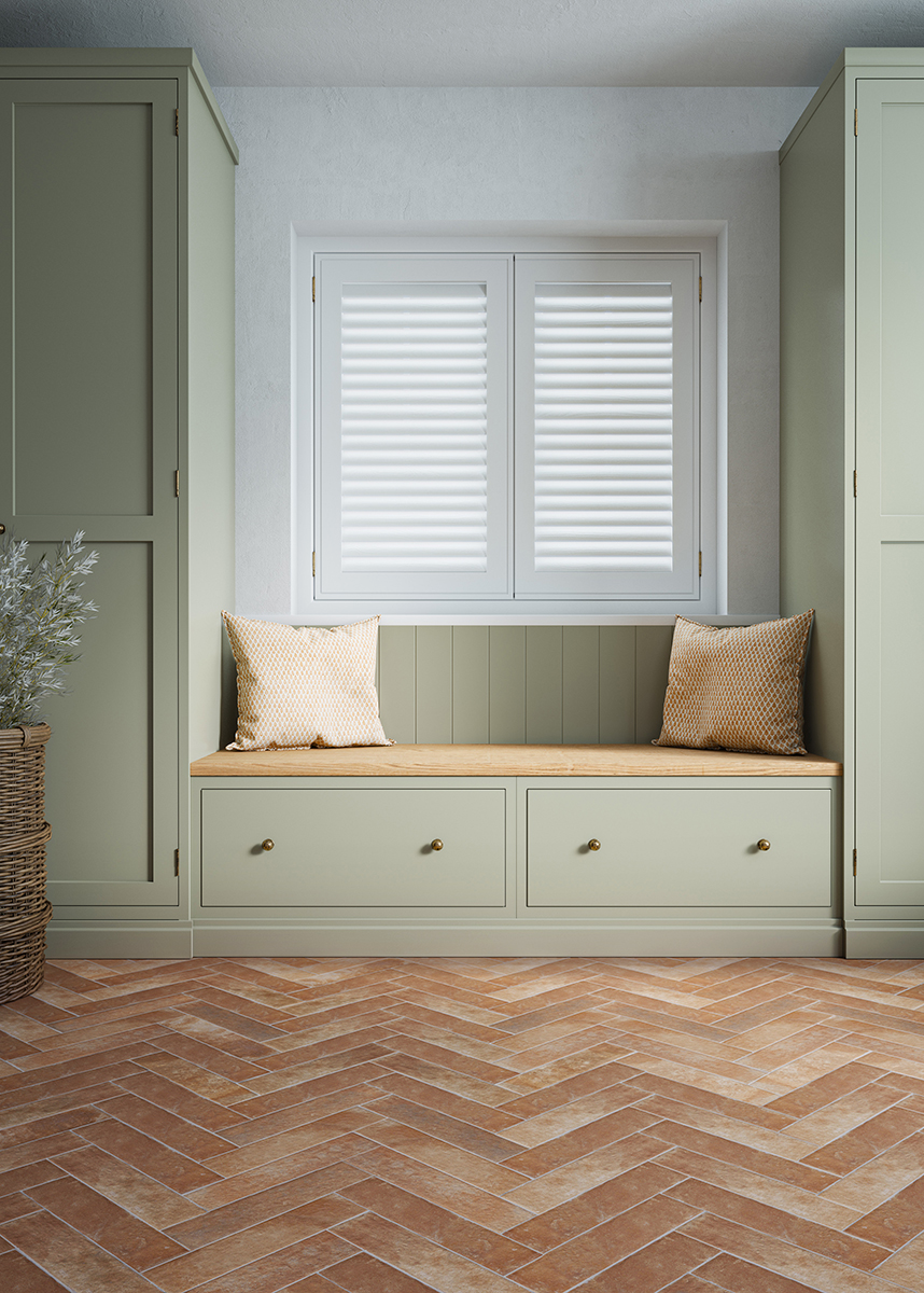 Oliva Rojo herringbone terracotta effect tiles on the floor with green cabinets with a bench