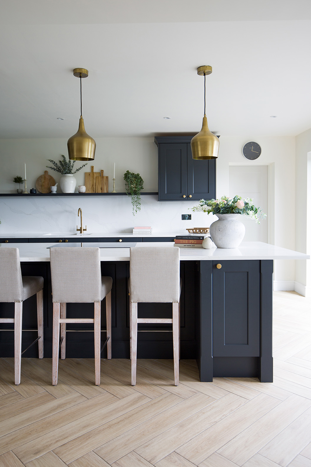 Falmouth Sandy Oak in a herringbone pattern with a dark blue island in a kitchen