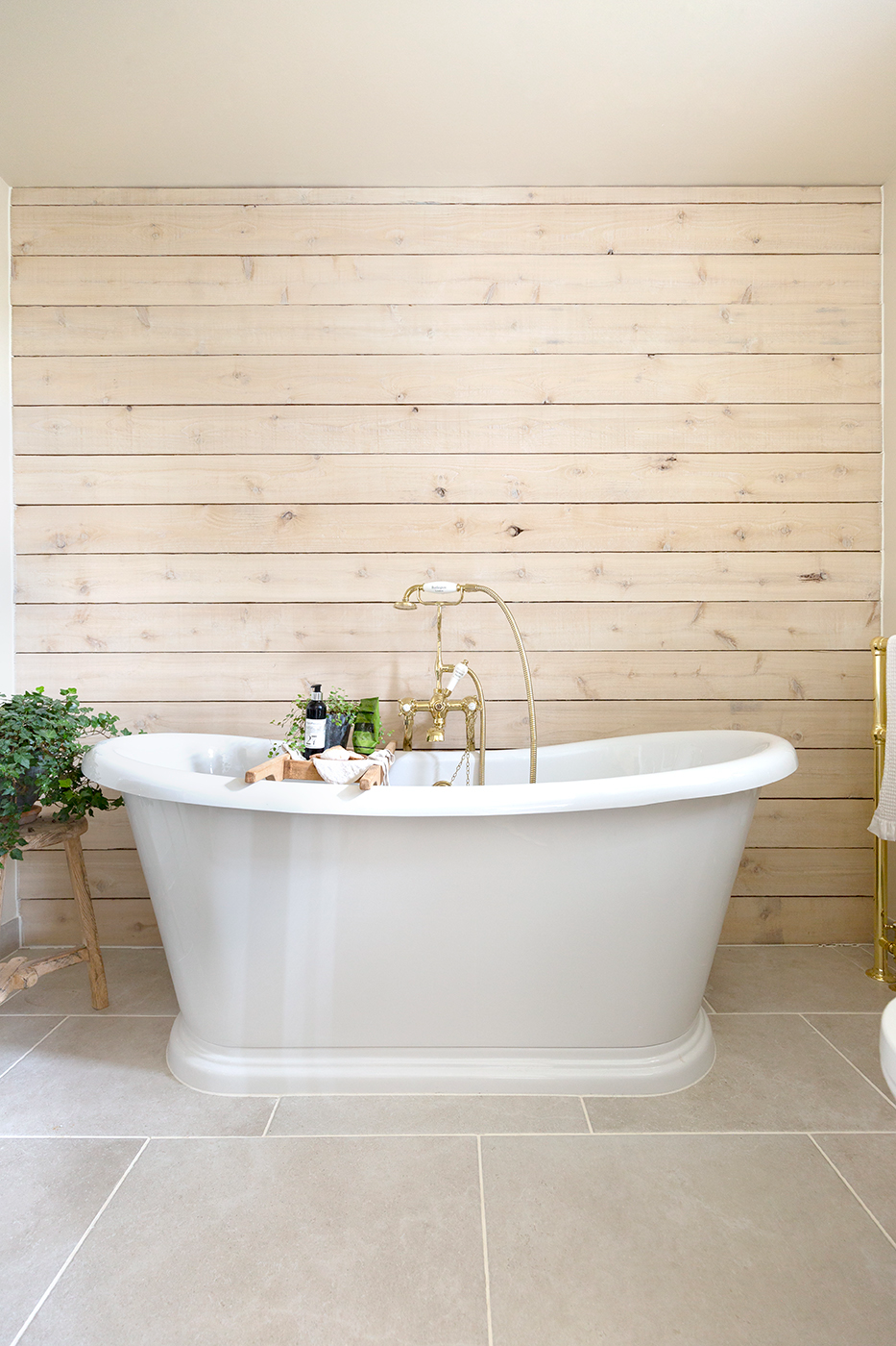 wood panel bathroom wall with white bathroom tiles and bath
