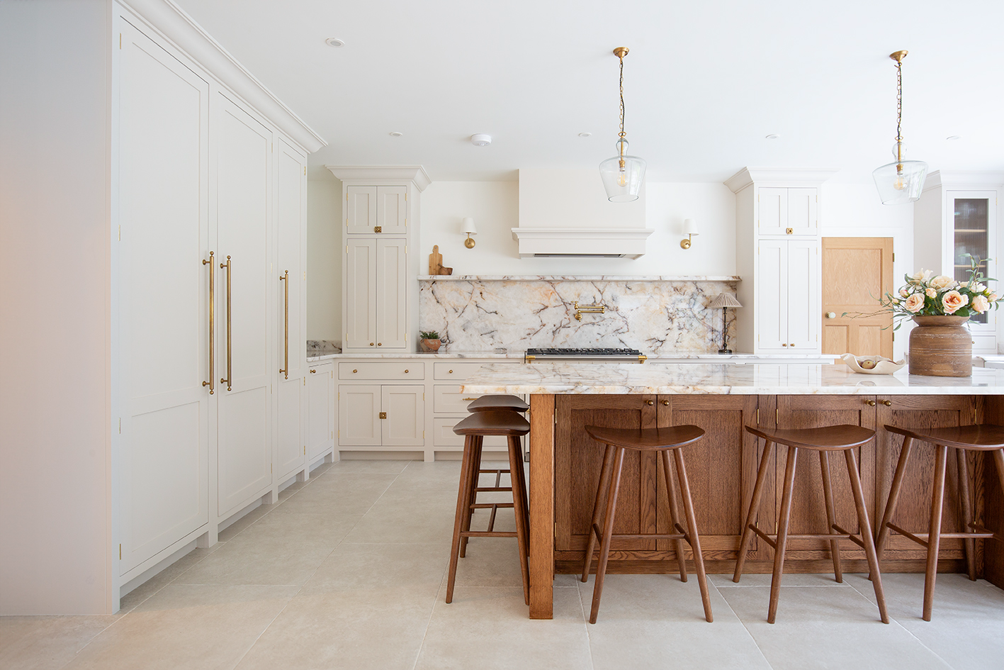 Wooden kitchen island with a marble splashback and ivory colour porcelain floor tiles 
