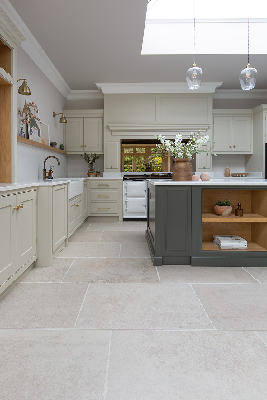 Chastleton ivory stone effect in a kitchen with a green island and cream cabinetry 