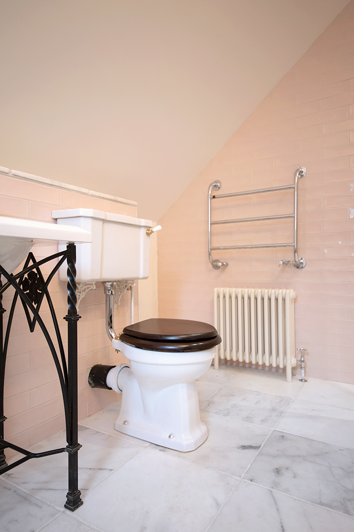 Modern bathroom tile inspiration featuring Primrose Blush metro tiles paired with a white toilet, creating a soft pink wall scheme with a glossy, contemporary finish.