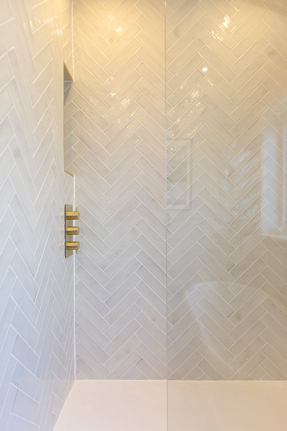 Nori Pearl in a herringbone shower area with white glossy metro tiles
