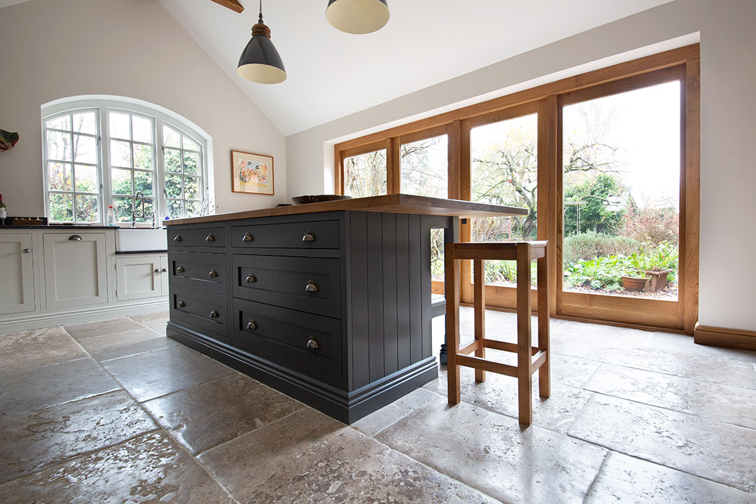 French Limestone flooring in a rustic style kitchen with an island
