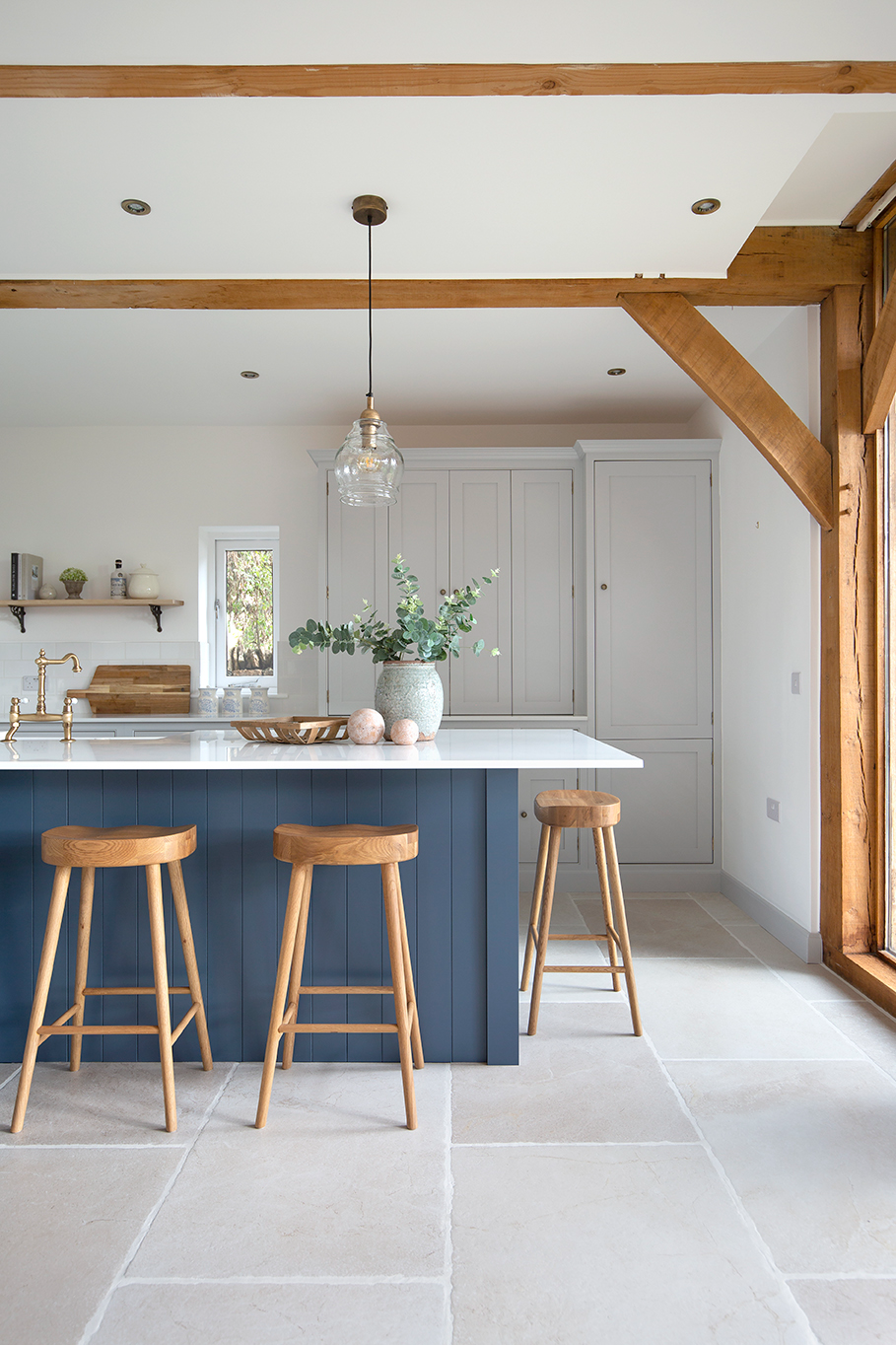 navy kitchen with large format porcelain tiles and oak beam ceiling