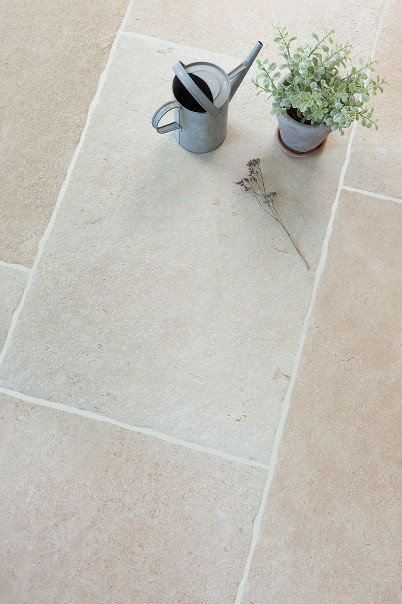 Flat lay with Lorient Beige paving tiles with plant pot and flowers