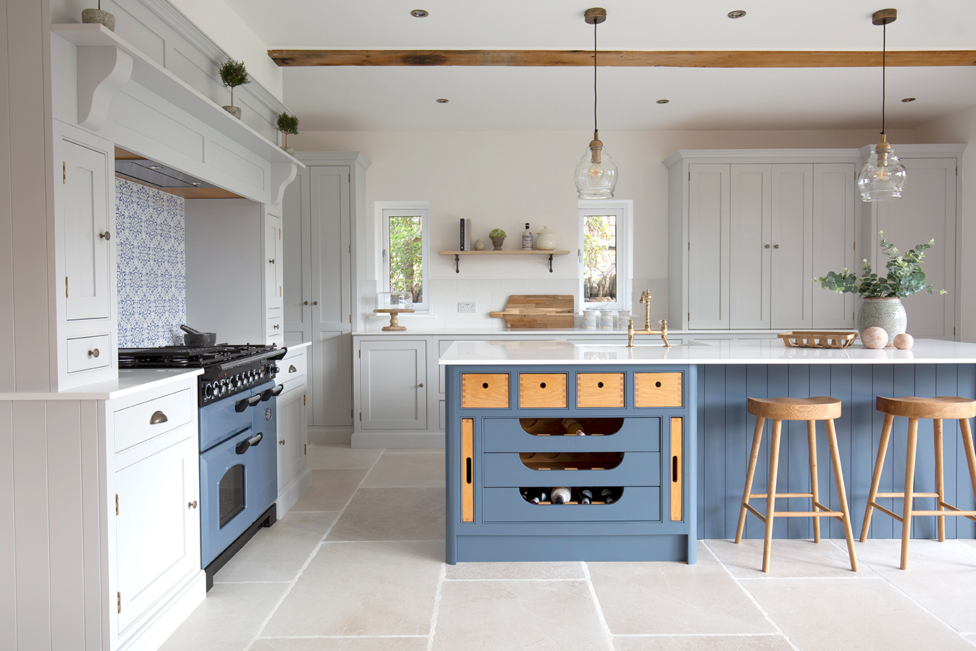 navy kitchen with large format porcelain tiles and oak beam ceiling