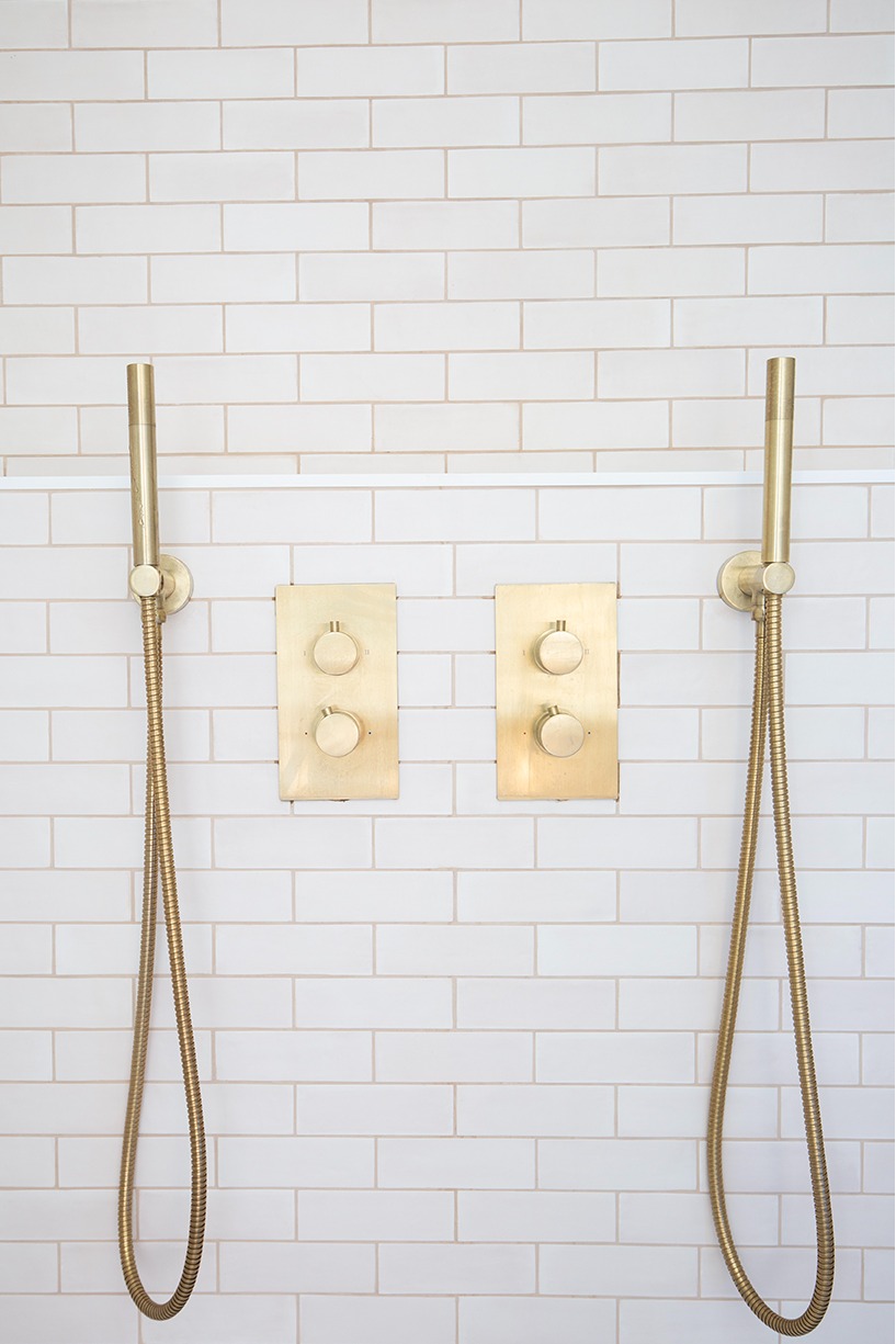 Close-up of Pastello Cotton matt metro tiles in a modern bathroom with a gold shower fixture, showcasing soft neutral tones and subtle texture for contemporary bathroom tile inspiration.