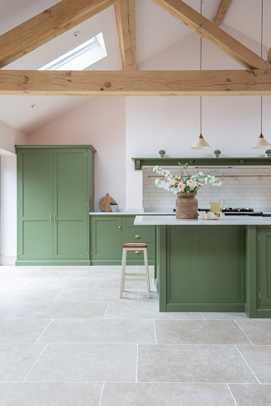 green kitchen with Dijon limestone natural stone floor in beige and oak beam ceiling