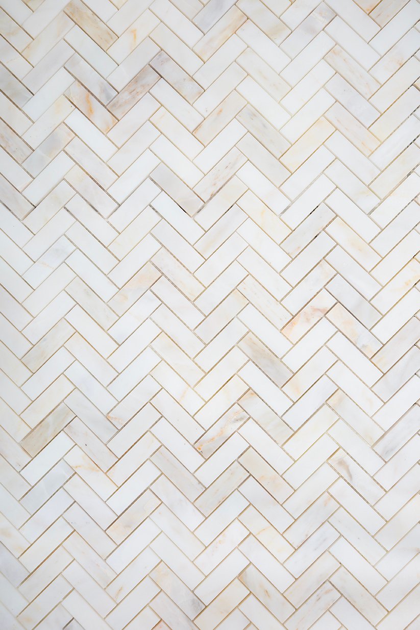 A close up of Carrara Oro herringbone pattern