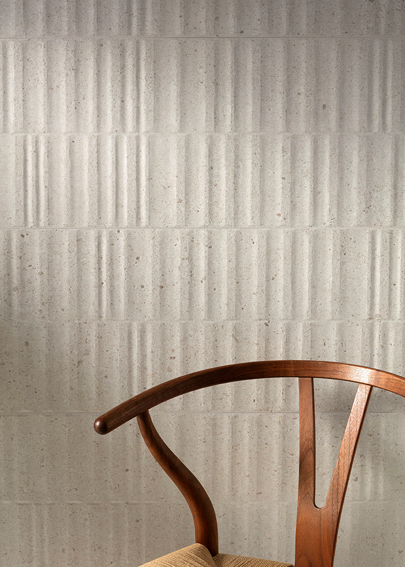 textured white wall tiles with wooden chair