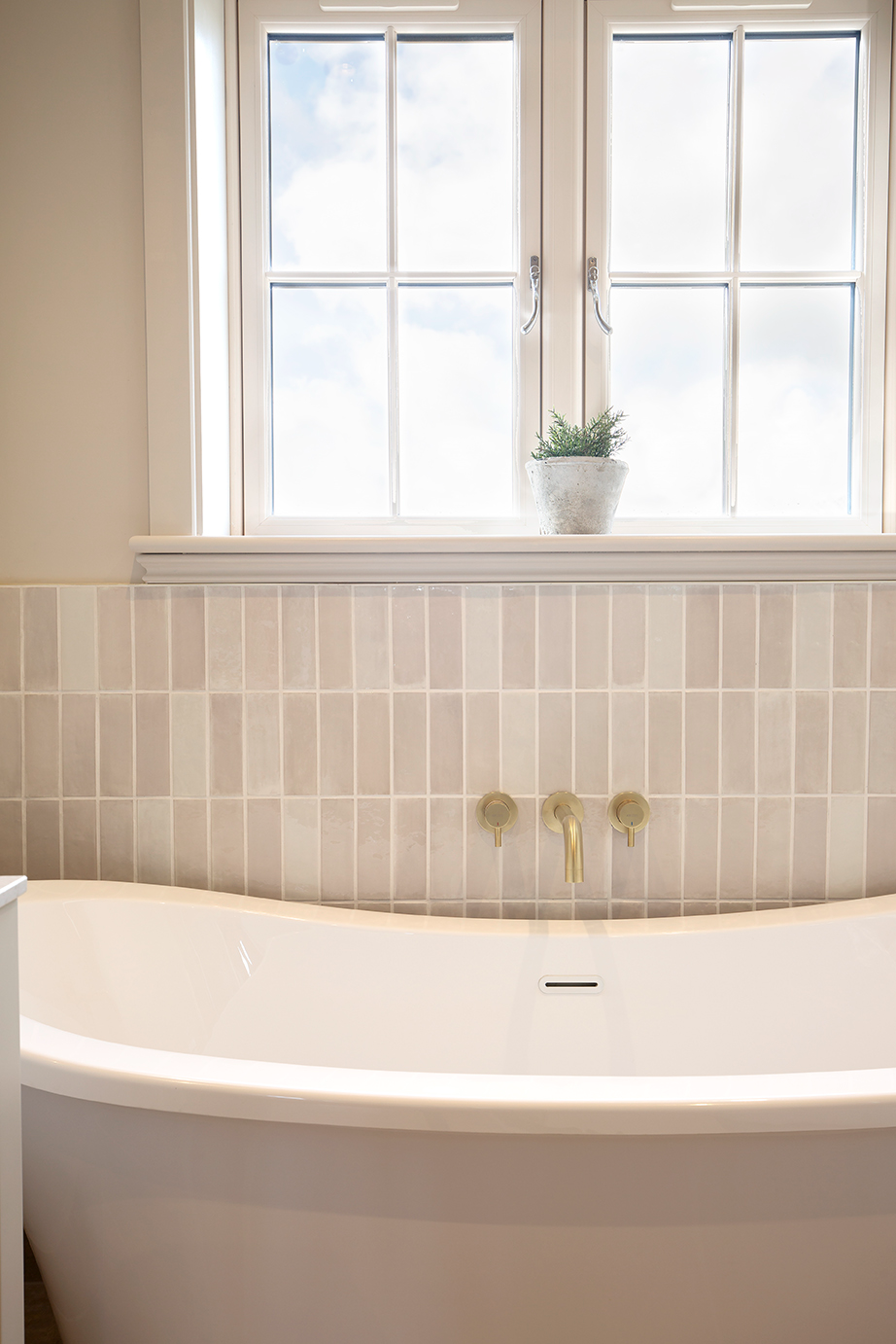 Pastello Seashell tiles in white bathroom with window bath and neutral metro tiles