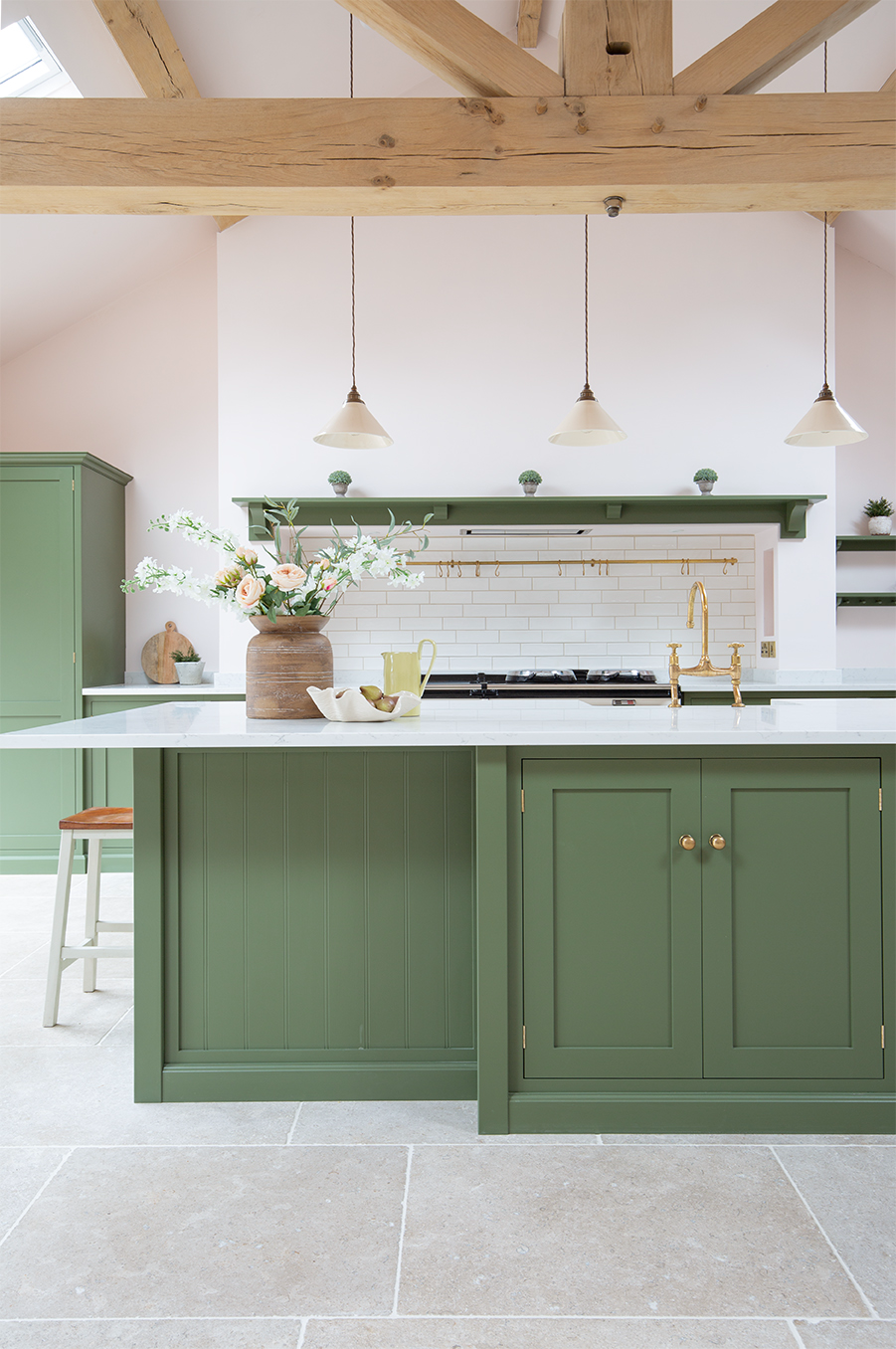Dijon Tumbled tfloor tiles with a green kitchen island and cabinets 