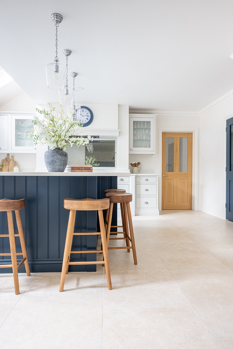 Dijon Rendition stone effect flooring in a kitchen with wooden stools and a navy island