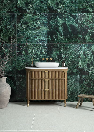 Modern bathroom tile inspiration showing Ravello Verde marble effect tiles on a bathroom wall with concrete sink and black tapware, highlighting textured veining and colour variation