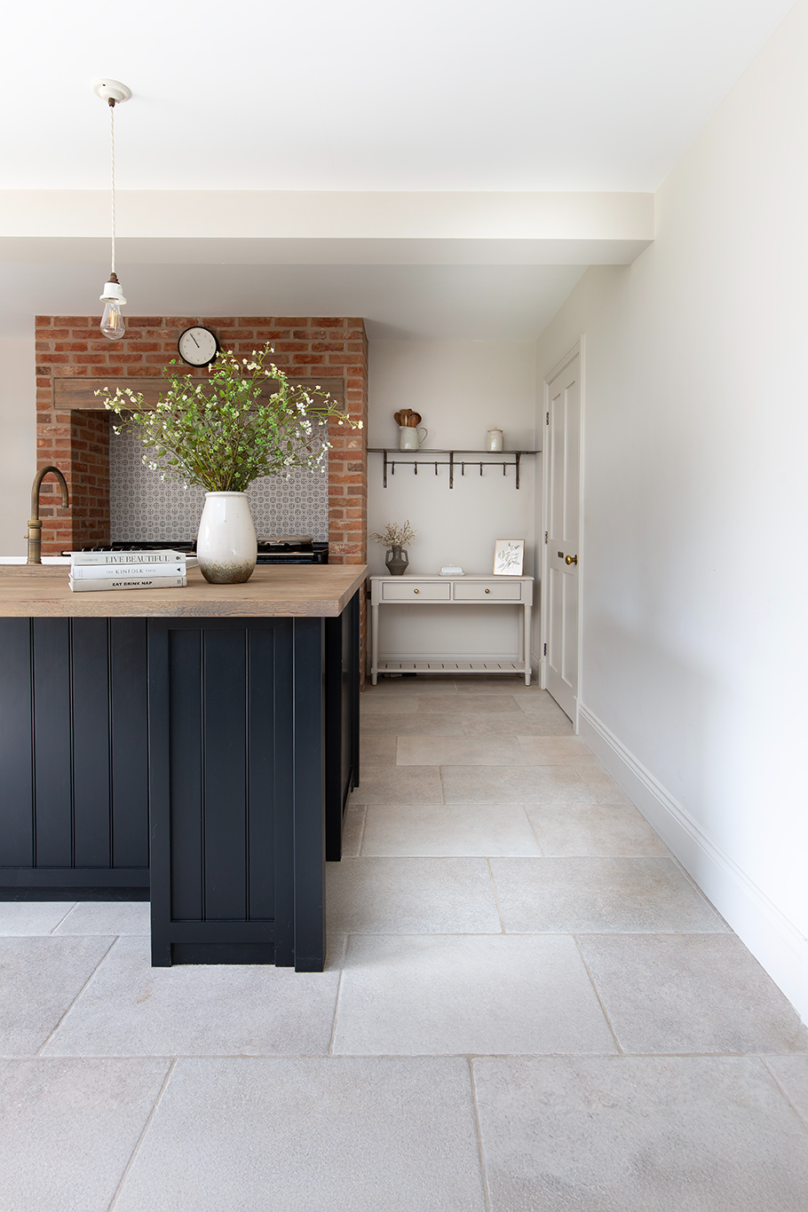 Lullington stone effect floor with navy units with floral decor on the white counter