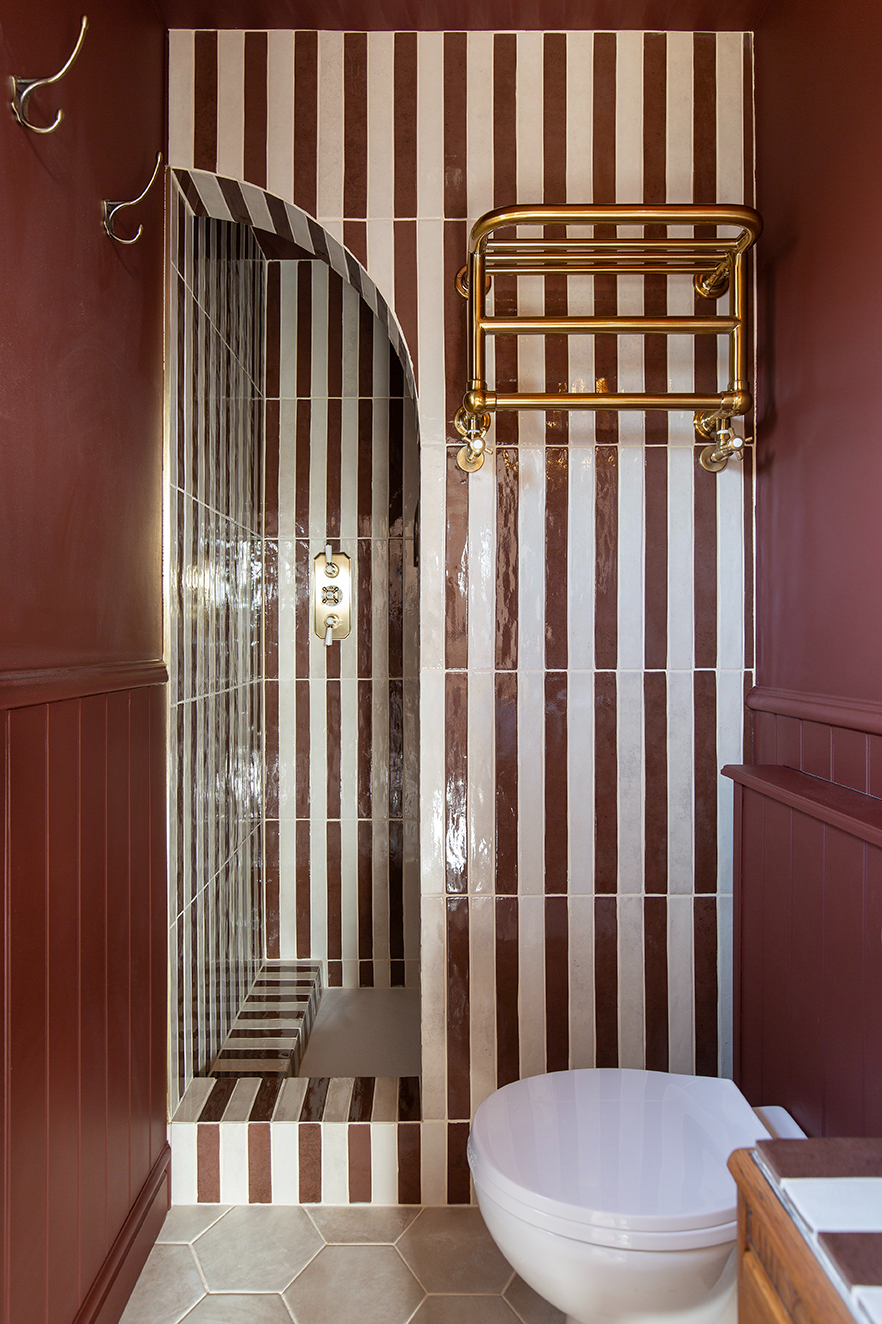 moody burgundy bathroom with striped tiles