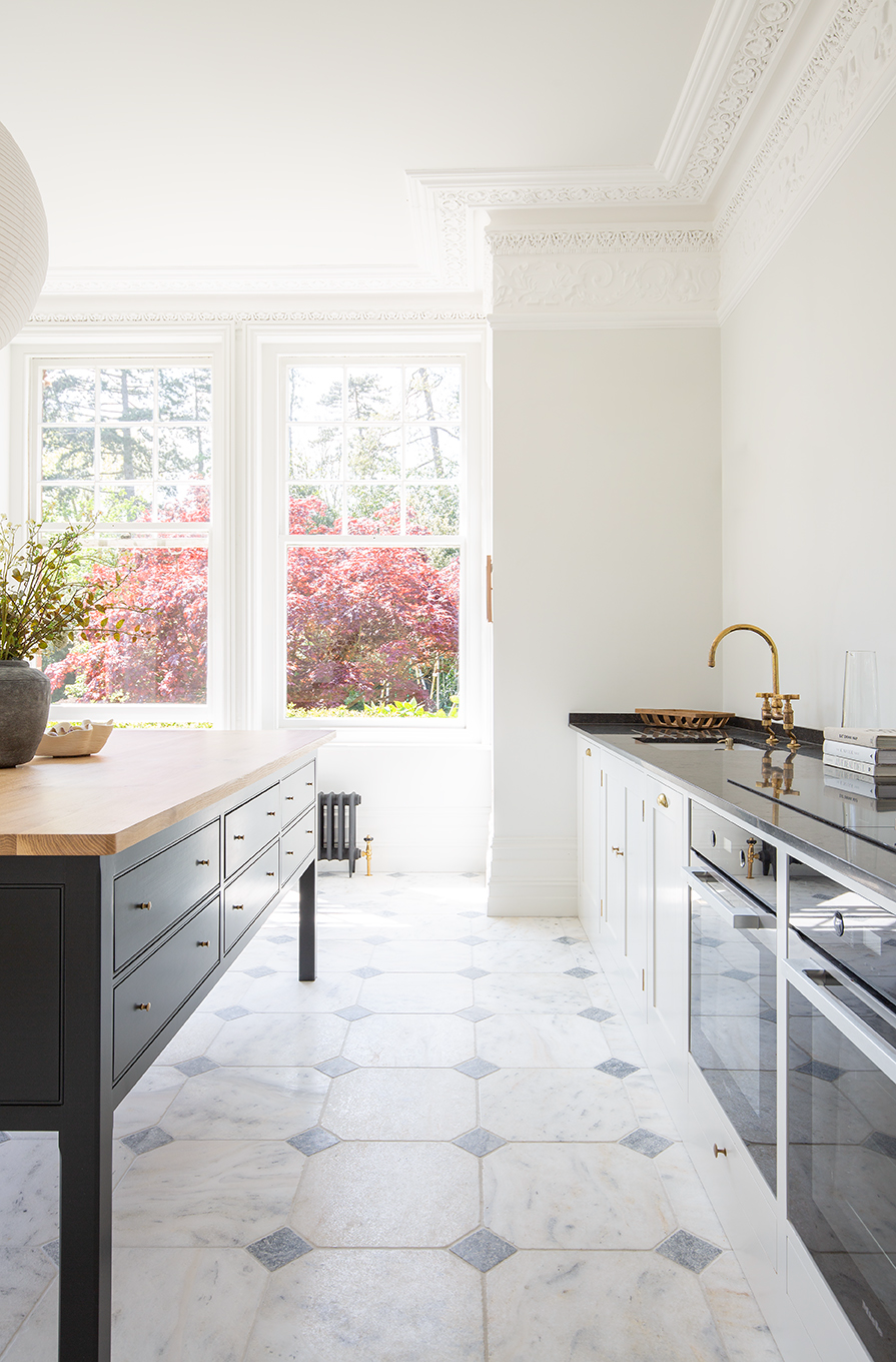 Parisian Manoir Flooring in a kitchen, featuring a dark blue island with a wooden top 