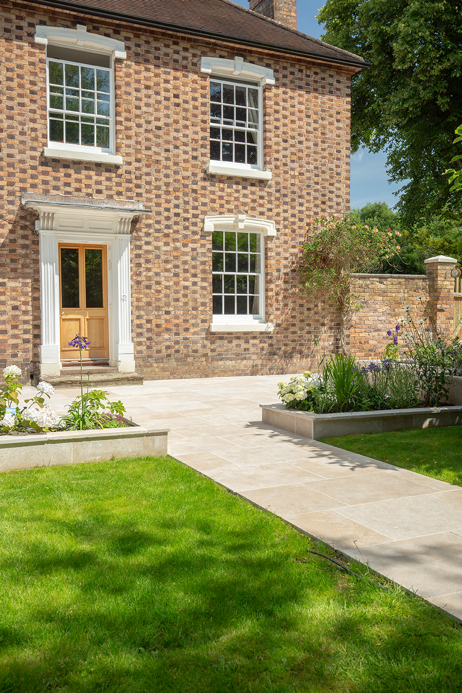 georgian house with beige flagstone pathway paving and planting