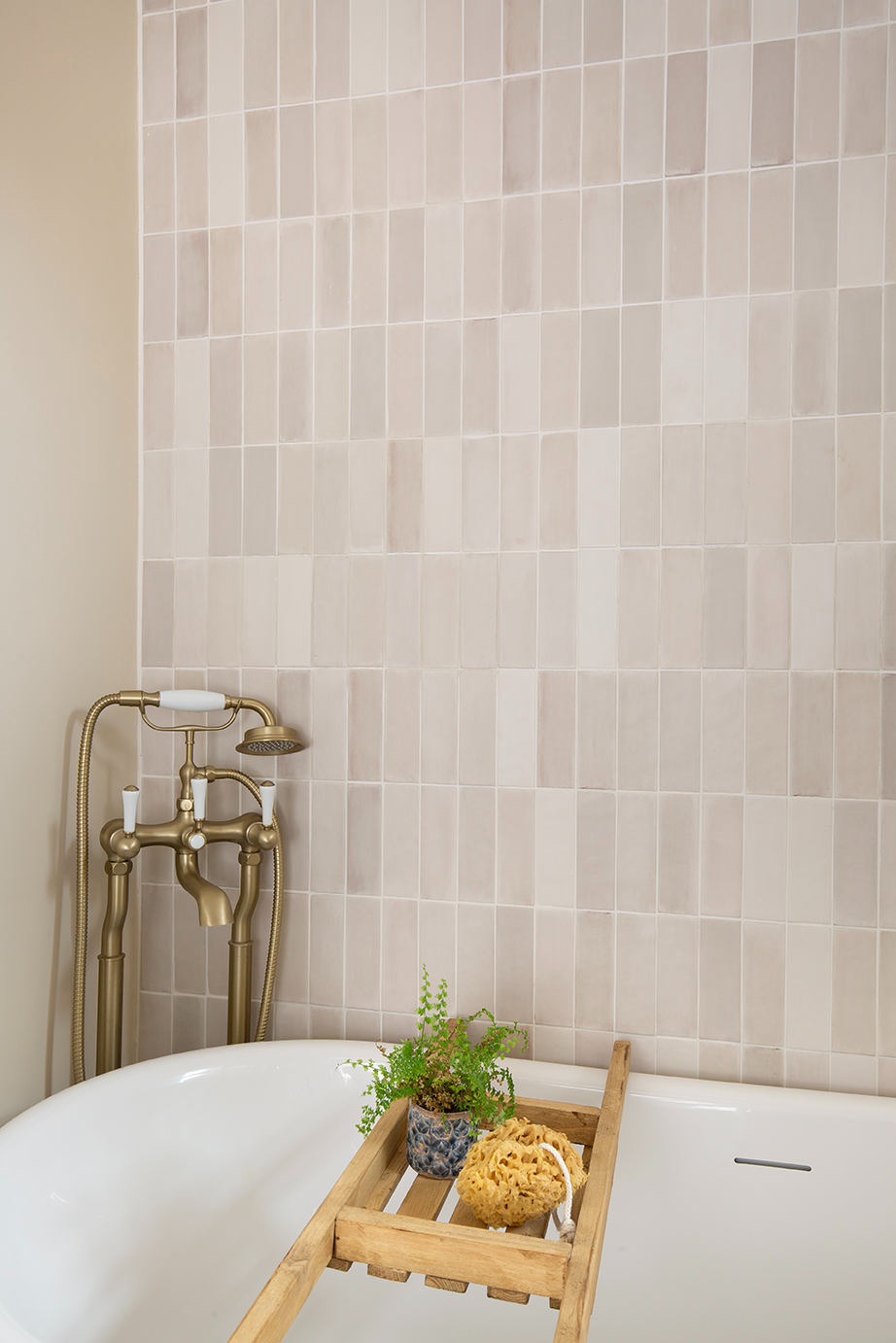 Close-up of Pastello Seashell matt metro tiles in a modern bathroom, highlighting soft beige tones alongside a white bath and gold taps for a sophisticated, contemporary look.