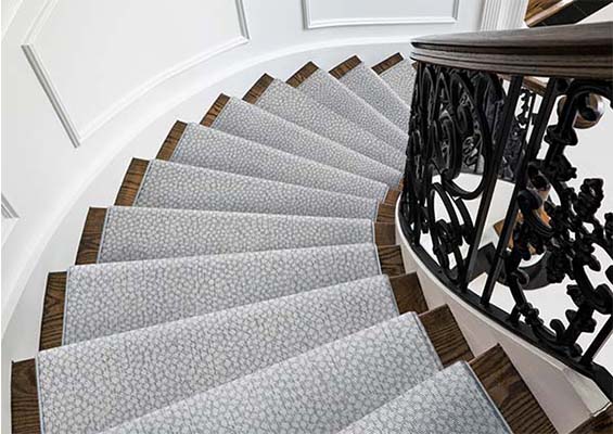 Light blue patterned custom stair runner on a spiral staircase
