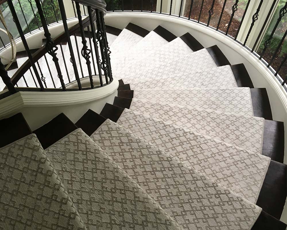 Beautiful spiral staircase with white patterned stair runner