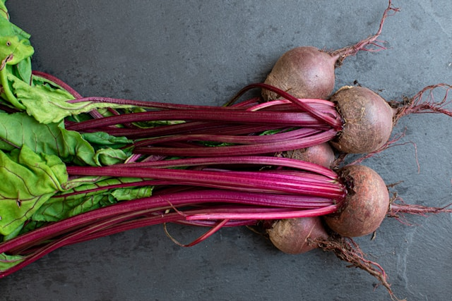 Fresh vibrant beetroots on a wooden table, symbolizing heart health and energy.