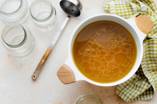 A comparison of watery chicken broth versus rich, concentrated bone broth powder.