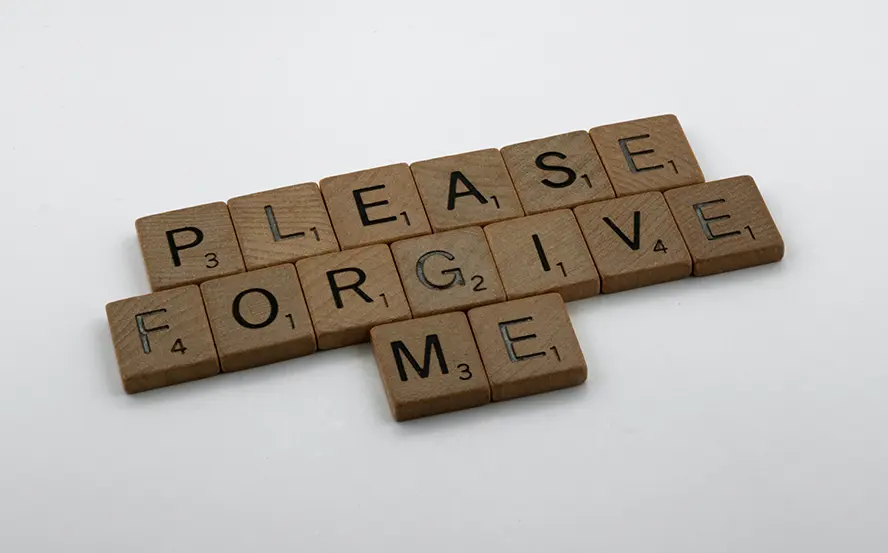A grouping of Scrabble tiles that read "Please forgive me."